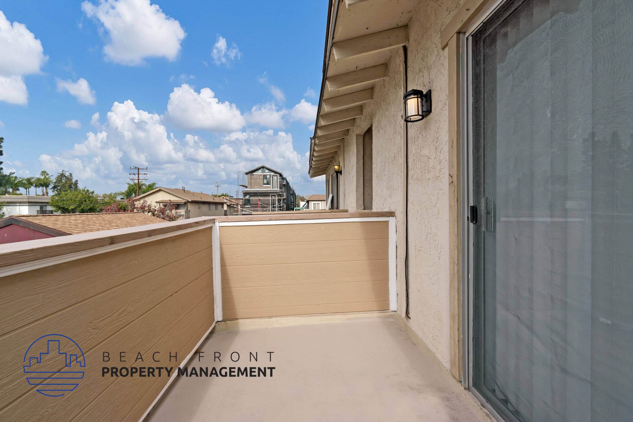 A balcony with a sliding door and a wall lamp.